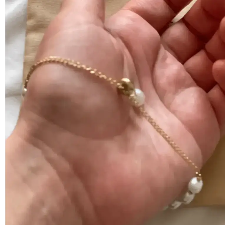 Bracelet femme avec perles blanches et chaîne dorée, un must-have pour un look raffiné