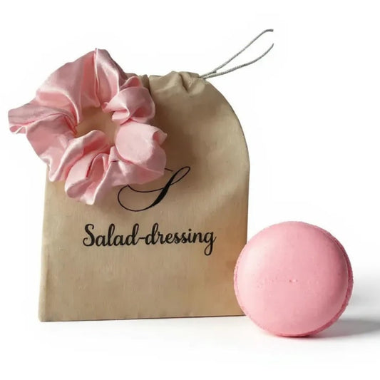 Chouchou cheveux en satin rose poudré posé sur fond blanc