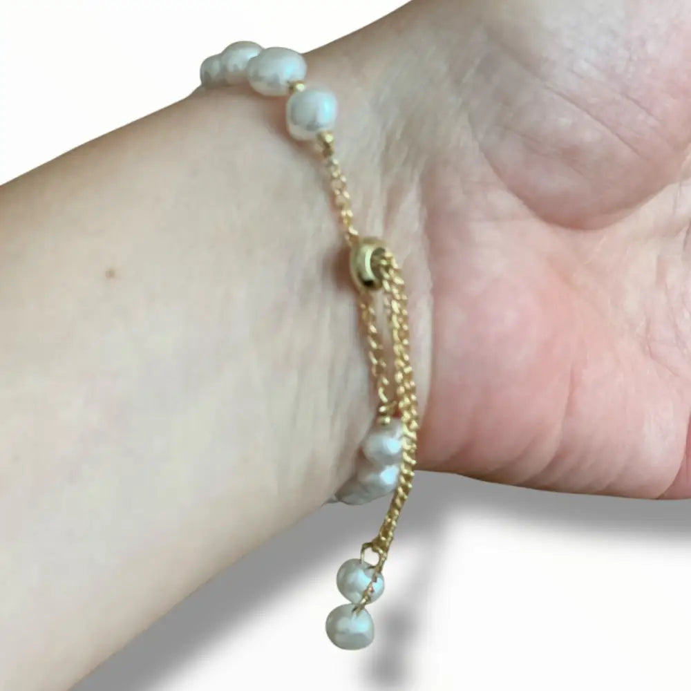 Bracelet féminin ajustable en perles blanches et chaîne dorée, un accessoire chic pour toutes les occasions