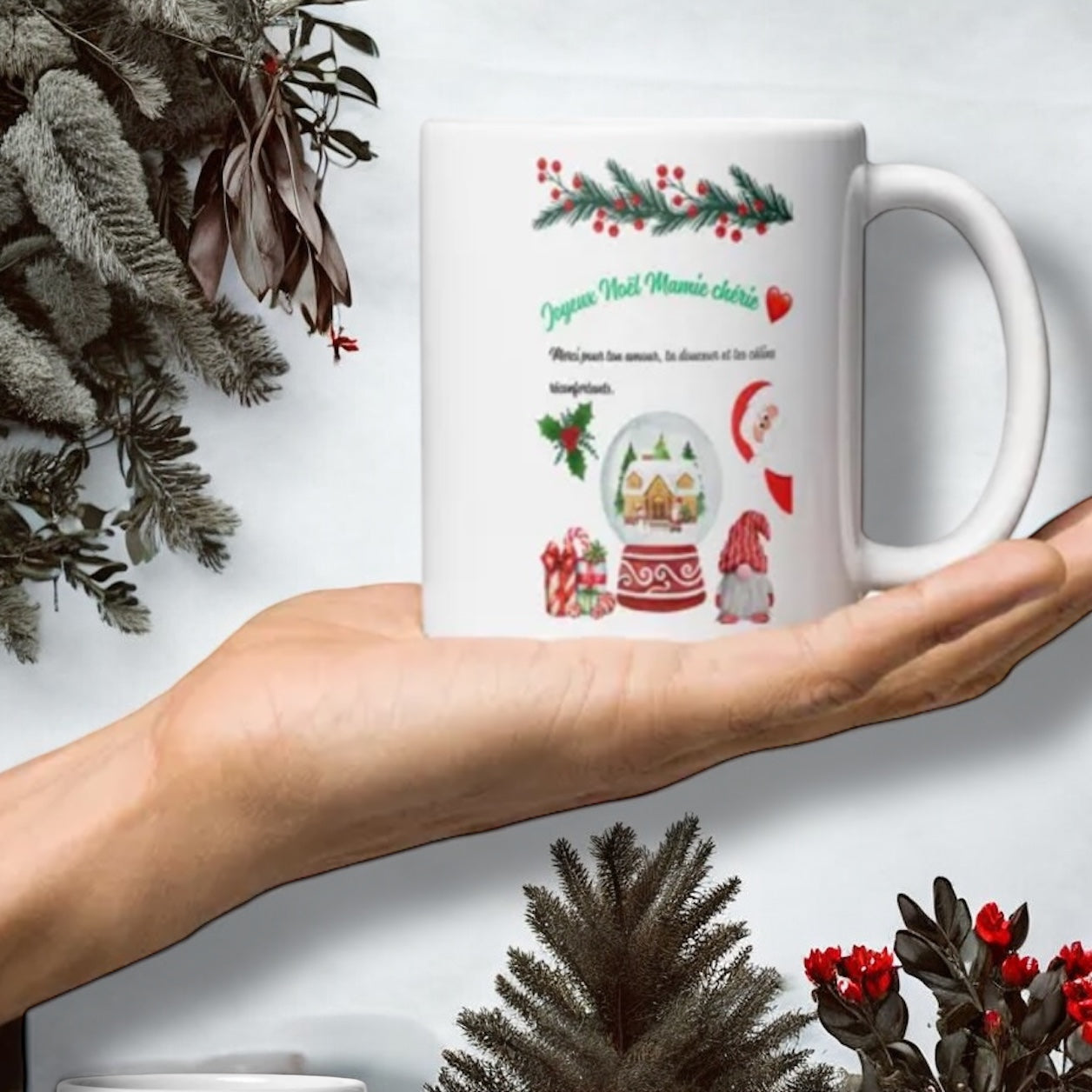 Tasse Joyeux Noël Mamie avec décorations de Noël sur table en bois